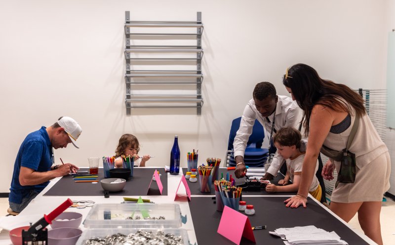 two instructors helping parents and small child with their art activities 